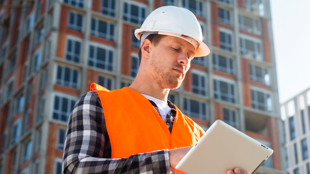 5medium-shot-low-angle-view-construction-engineer-looking-tablet